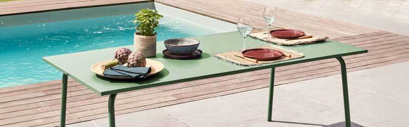 mesa de jardín de metal junto a piscina